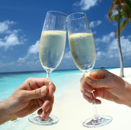 Zwei Personen stoßen mit Champagner an einem Strand in Panama an